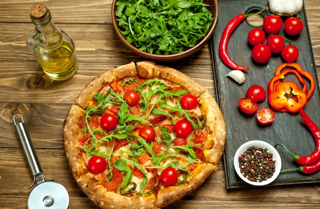 pizza with ingredients on wood background