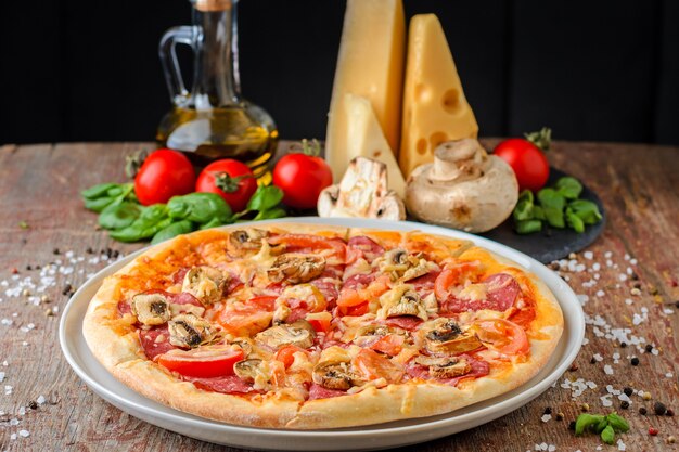 Pizza con gli ingredienti su un fondo di legno, fine su