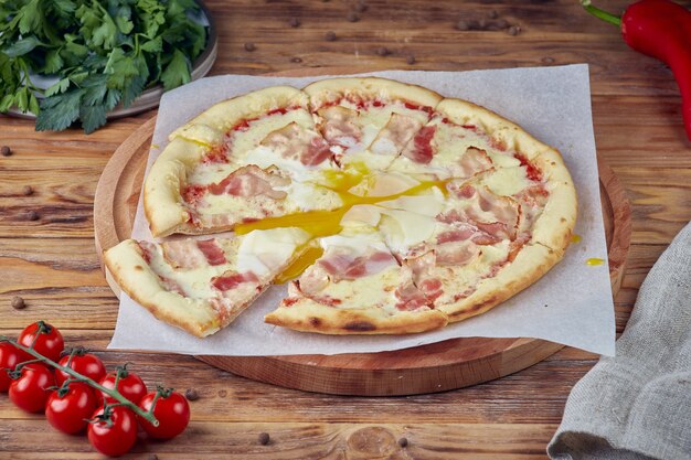 Pizza with meat, vegetables and mushrooms, wooden background