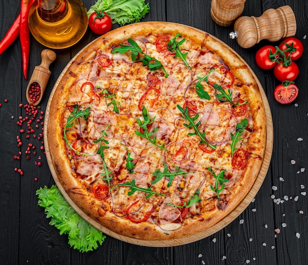 Pizza with Mozzarella cheese salami chicken meat beef ham Tomato sauce pepper spices Italian pizza on dark background