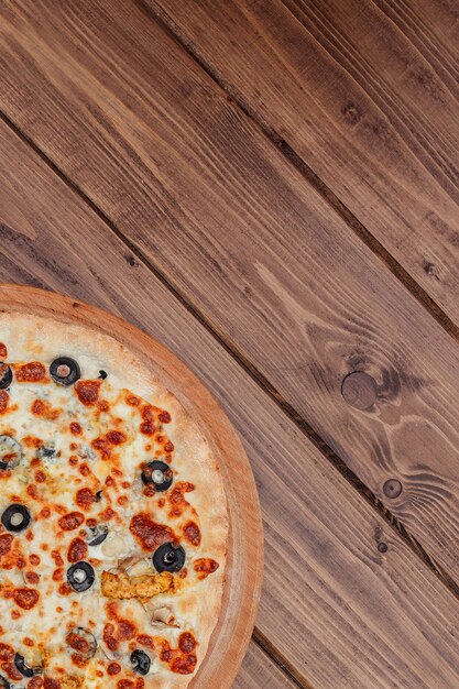 Pizza with Mozzarella cheese on wooden table