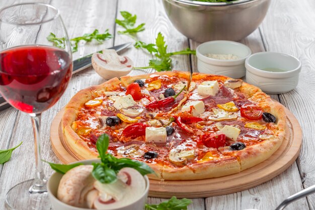 Pizza with Mozzarella, Ham, Cherry Tomatoes, Black Olives