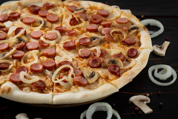 Foto pizza con funghi e cipolle caramellate su fondo di legno