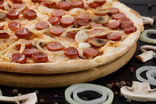 Pizza with mushrooms and caramelized onions on wood background