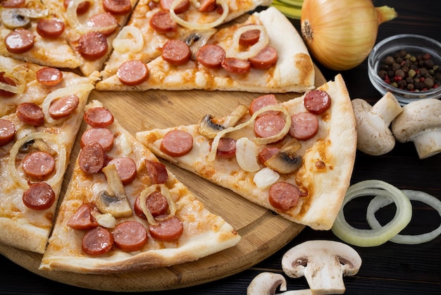 Pizza with mushrooms and caramelized onions on wood background