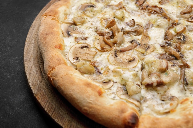 Pizza with mushrooms and chicken on a dark background