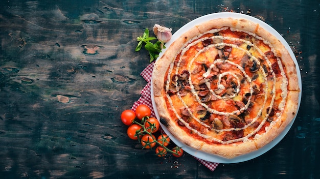 Pizza with mushrooms, sausage and mustard. On a wooden background. Top view. Free space for your text.