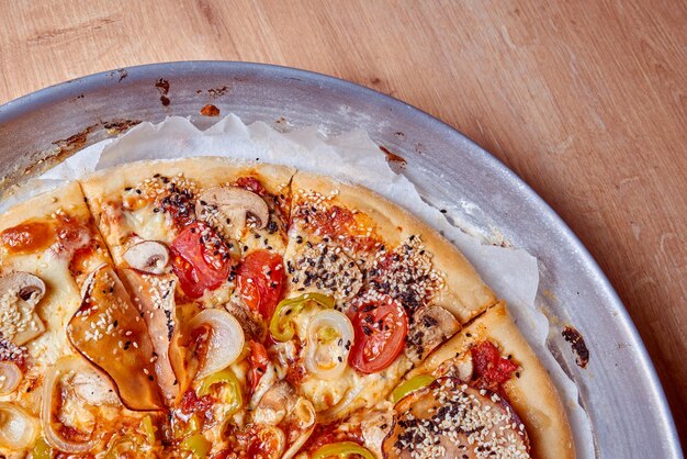 Foto una pizza con sopra funghi, pomodori e peperoni verdi