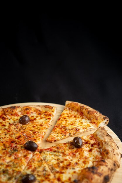 A pizza with olives on it and a slice missing.