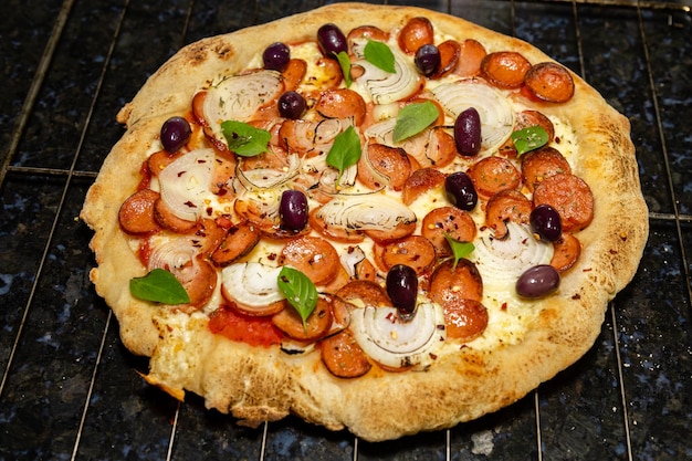 A pizza with olives, olives, and mushrooms on a wire rack.