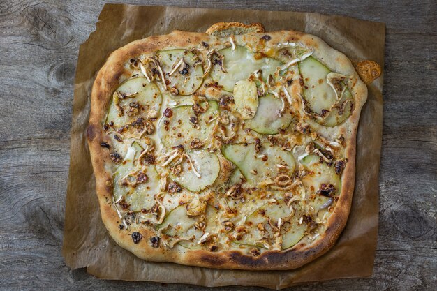 Pizza with pear, cheese and walnuts. A variation of vegetarian pizza. Food  background