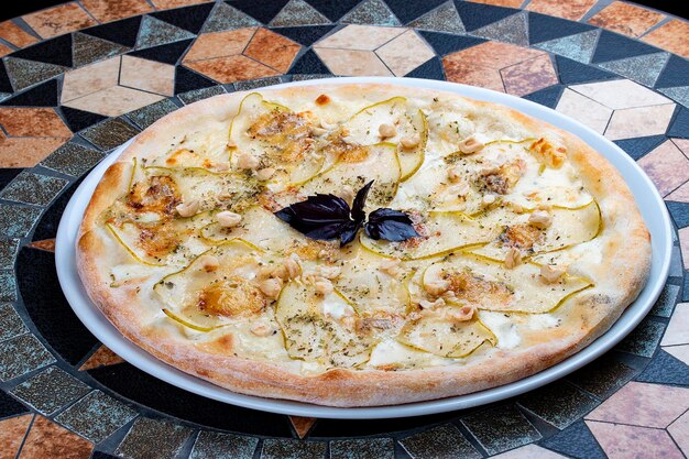 Pizza with pear and Gorgonzola cheese on a stone table