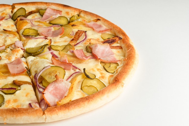 Pizza with pickles bacon potatoes onions and cheese on a white background