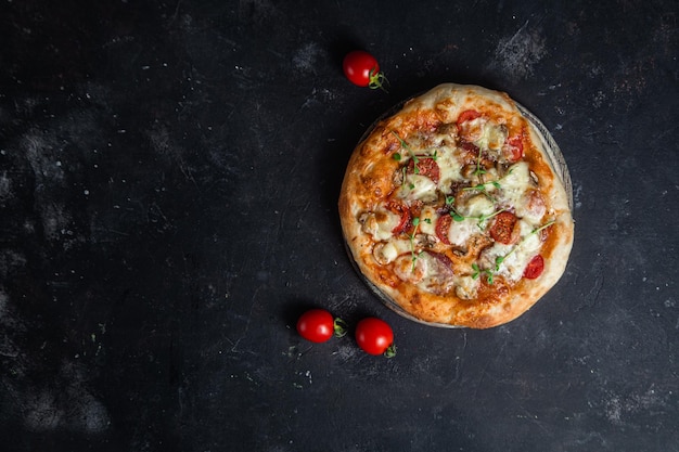 Фото Пицца с салями и грибами на темном фоне