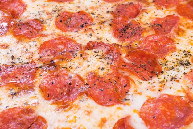 Pizza with salami and cheese closeup background