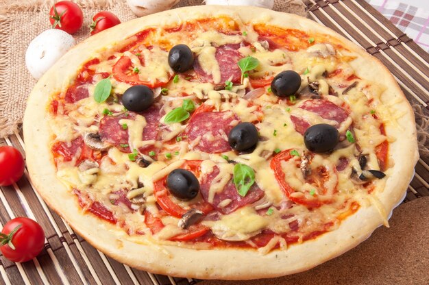 pizza with salami, tomatoes and mushrooms