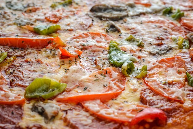 Pizza with salami, tomatoes, pepper and mushrooms