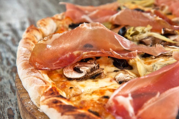 Foto pizza con prosciutto serrano funghi porcini e olive nere tritate gastronomia