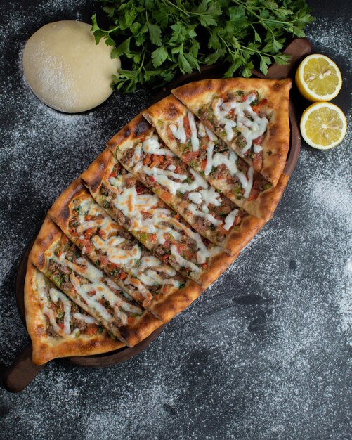 A pizza with a slice of pizza on a wooden board.