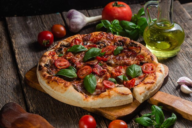 A pizza with tomatoes, basil, and basil on a wooden table.