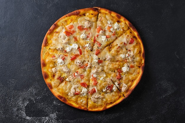 Pizza with tomatoes chicken onions feta cheese mozzarella cheese and spices