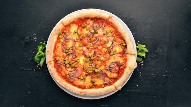 マグロと玉ねぎのピザ。イタリアの伝統料理。古い背景に。上面図。テキスト用の空き容量。