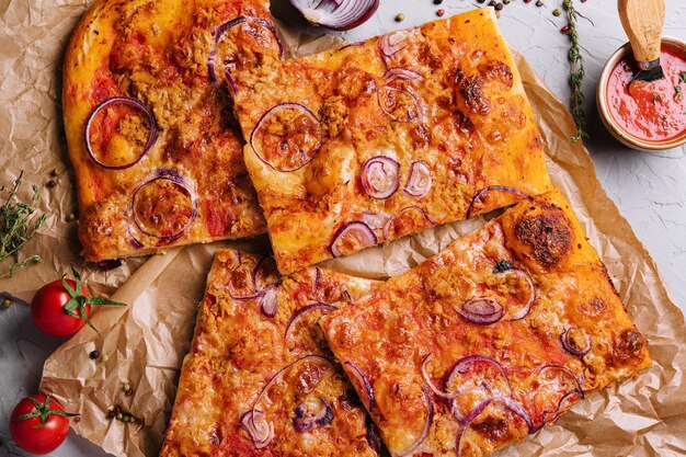 Pizza with tuna and red onion top view