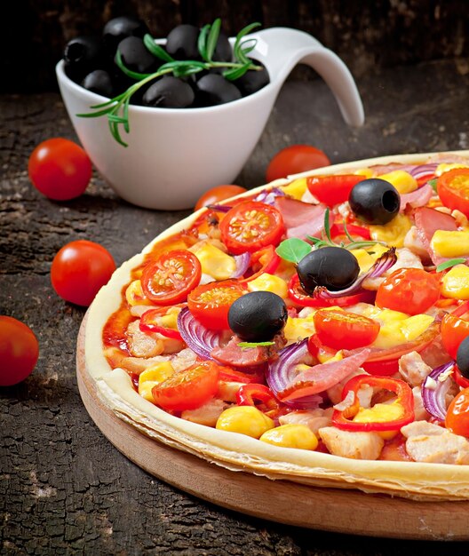 Photo pizza with vegetables chicken ham and olives isolated on white