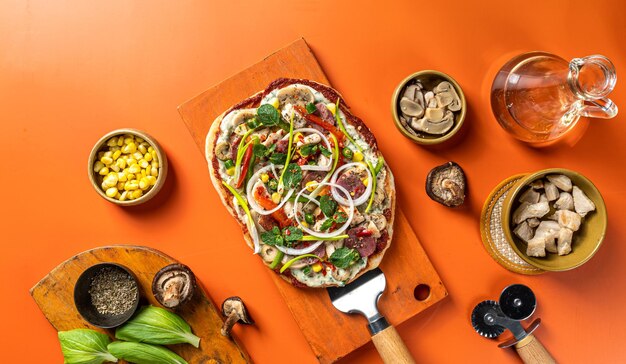 Pizza with vegetables, chicken, mashroom, ham and olives isolated on wooden board flat lay