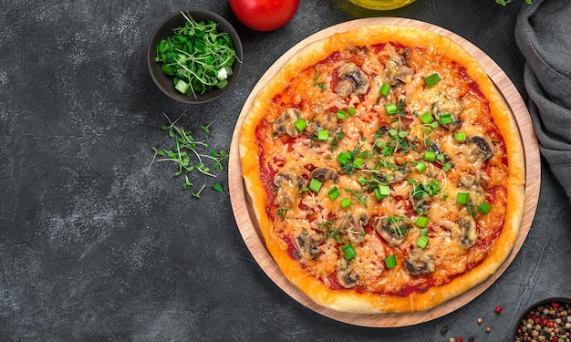 Pizza with vegetables and fresh herbs on a black background