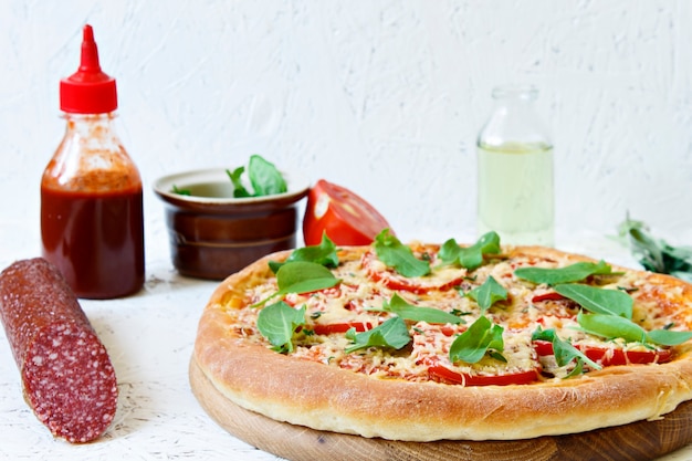 Pizza on a wooden board on a white background. Ingredients for pizza