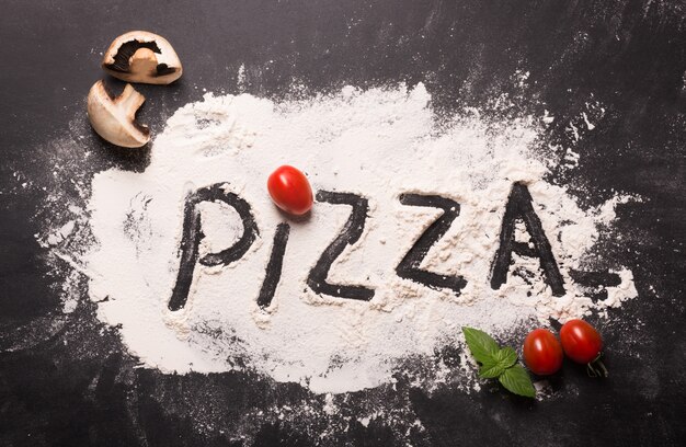 Foto parola della pizza su farina con gli ingredienti