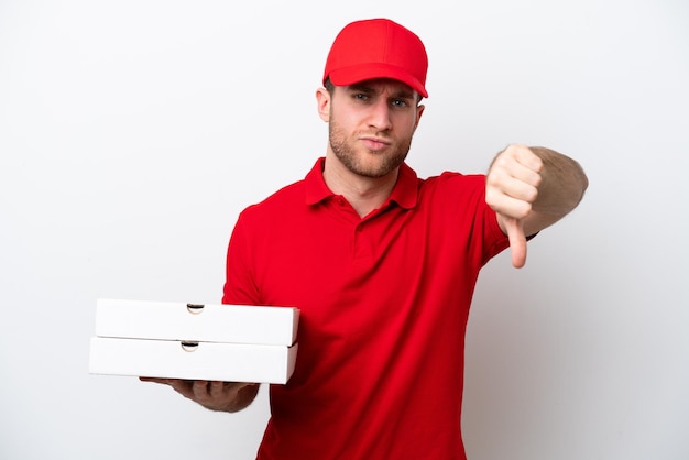 Pizzabezorger blanke man met werkuniform oppakken van pizzadozen geïsoleerd op een witte achtergrond met duim omlaag met negatieve uitdrukking