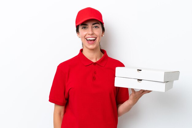 Pizzabezorger blanke vrouw met werkuniform oppakken van pizzadozen geïsoleerd op een witte achtergrond met verrassende gezichtsuitdrukking