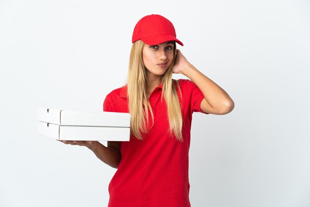 Pizzabezorger die een pizza houdt die op witte muur wordt geïsoleerd die twijfels heeft