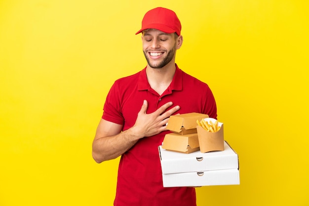 Pizzabezorger die pizzadozen en hamburgers ophaalt over een geïsoleerde achtergrond die veel lacht