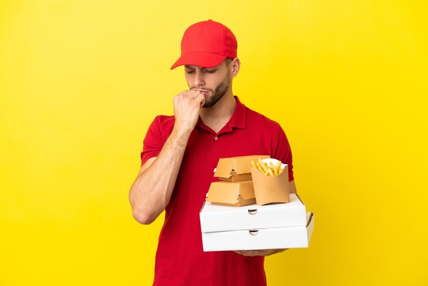 Pizzabezorger die pizzadozen en hamburgers ophaalt over geïsoleerde achtergrond met twijfels