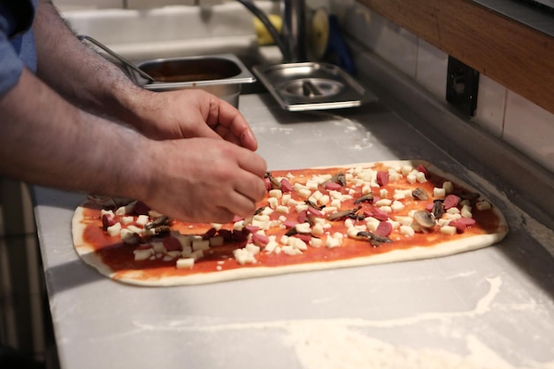 Pizzachef zet saus op basis in een commerciële keuken