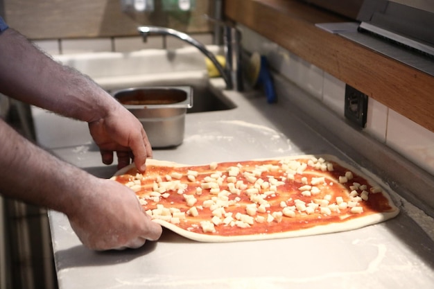 Pizzachef zet saus op basis in een commerciële keuken