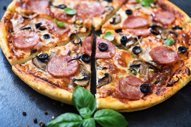 Pizzaplakken met champignons en olijven op een zwarte achtergrond