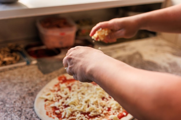 Pizzeria chef-kok onherkenbare handen bereiden een verse pizza professionele keuken bakkerij maken