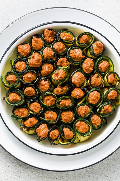 Photo pkhali. vegan appetizer from georgian cuisine. a soft mixture of grilled bell peppers and walnuts with spicy spices, wrapped in grilled zucchini leaves. healthy cuisine.