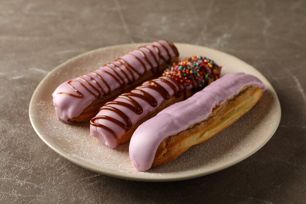 Plaat met eclairs met vla op grijs