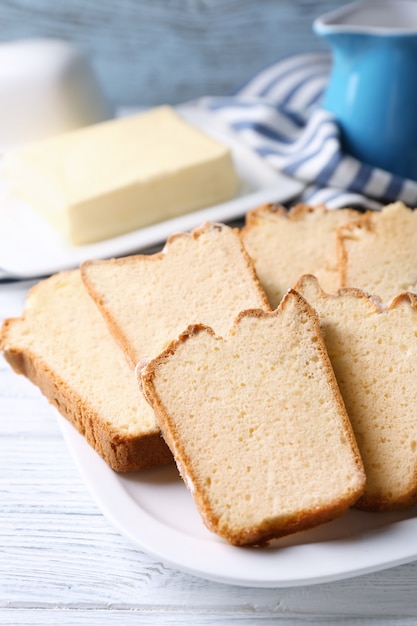 Plaat met heerlijke gesneden botercake op houten tafel