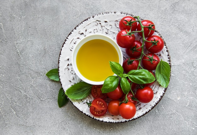 Plaat met kersentomaten, olijfolie en basilicum