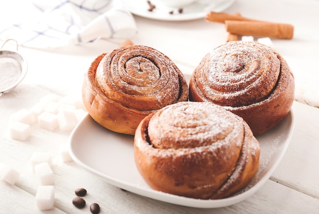 Plaat met lekkere kaneelbroodjes op tafel