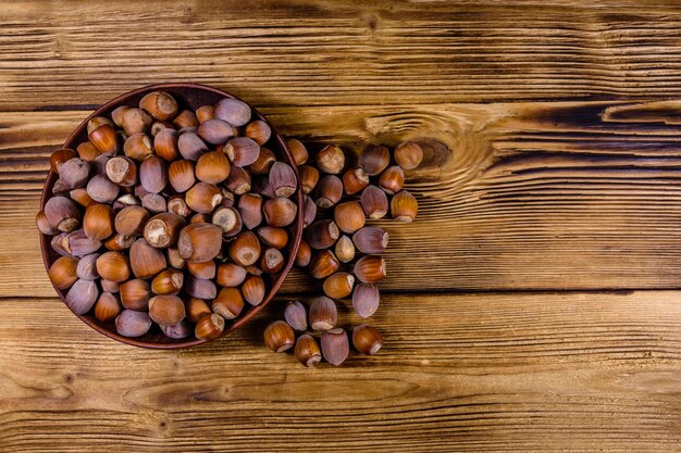 Plaat met stapel hazelnoten op een houten tafel. Bovenaanzicht