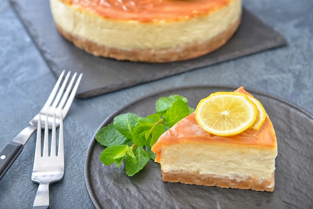 Plaat met stukje smakelijke cheesecake op donker