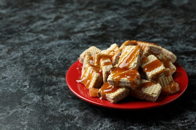 Plaat met wafels met karamel op zwarte smokey tafel