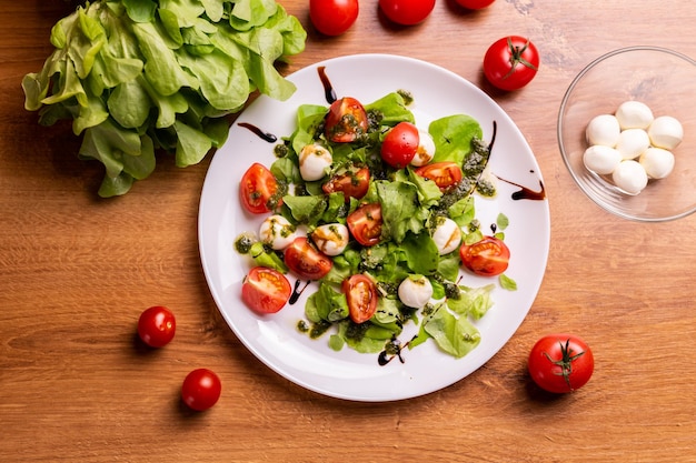 Plaat van gezonde klassieke bovenaanzicht caprese salade met mozzarella kaas, tomaten en basilicum in de italiaanse keuken